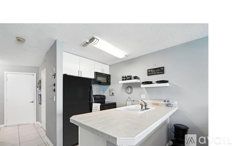 A kitchen with a white counter and black appliances.