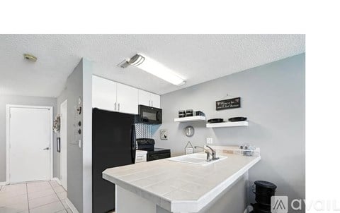 A kitchen with a white counter and black appliances.