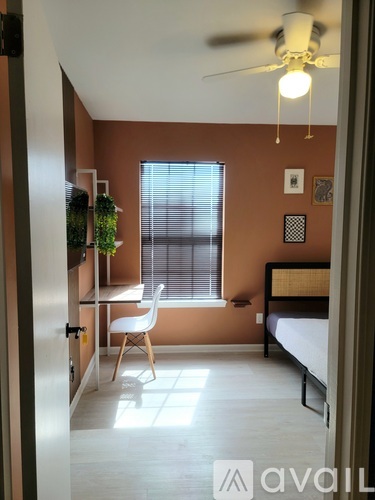 A bedroom with a bed, desk, and chair.