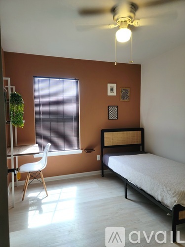 A bedroom with a bed, desk, and chair.