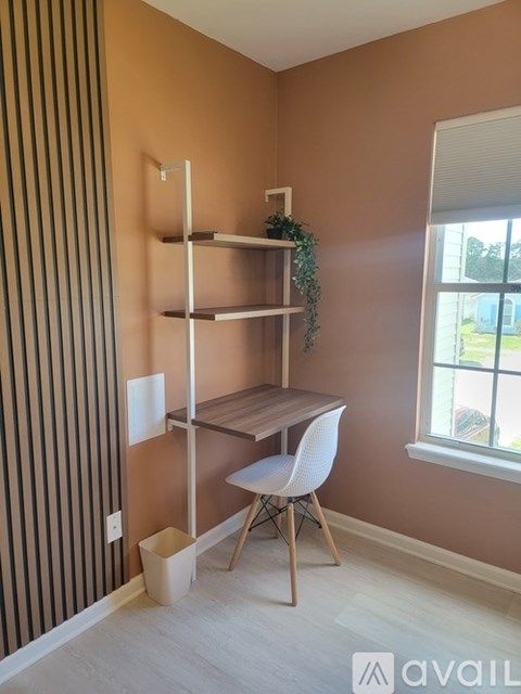 A bedroom with a bed, desk, and chair.