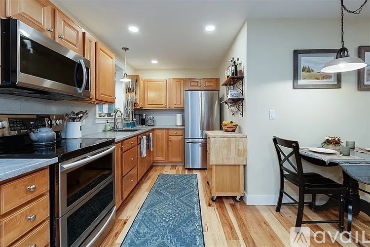 A kitchen with wooden cabinets and a black refrigerator.