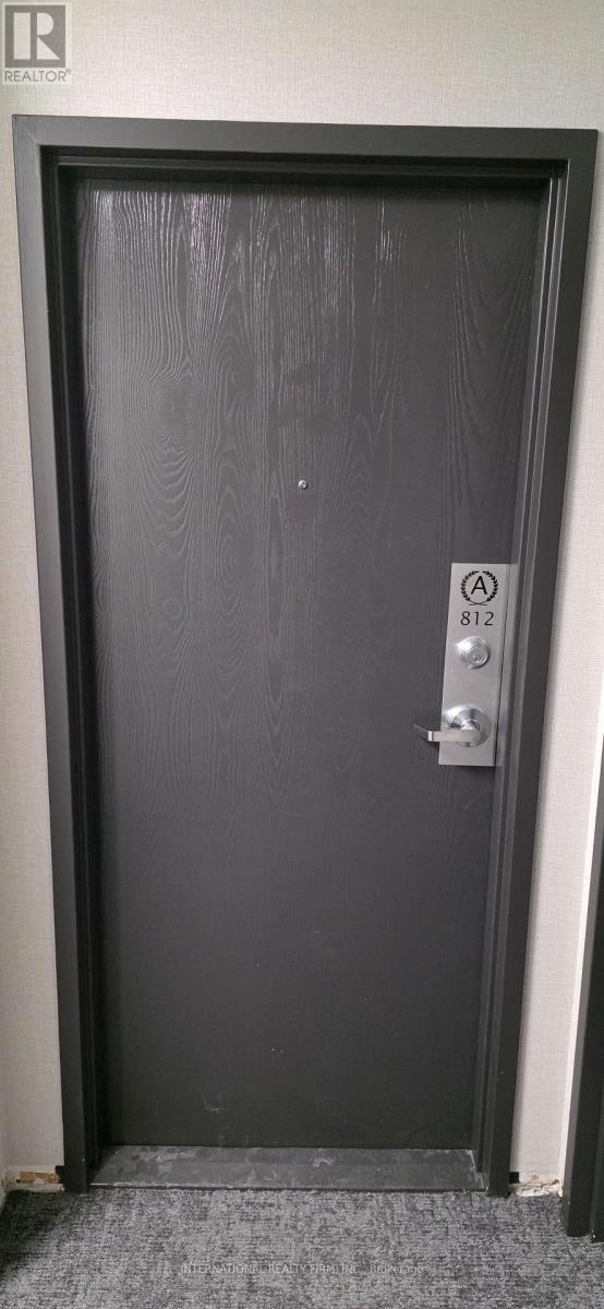 A black door with a silver handle and a sign on it.