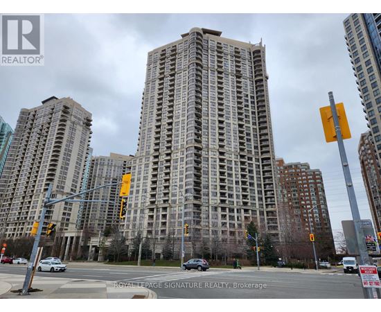 A tall building with many windows is in the background of a busy street.