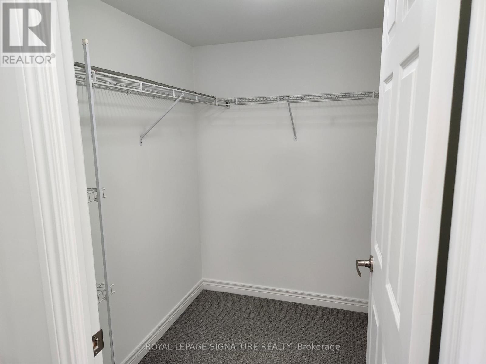 A white bedroom with a white door and a white wall.