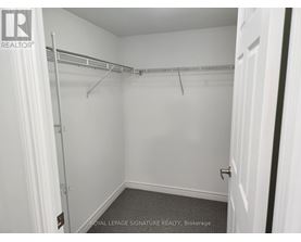 A white bedroom with a white door and a white wall.