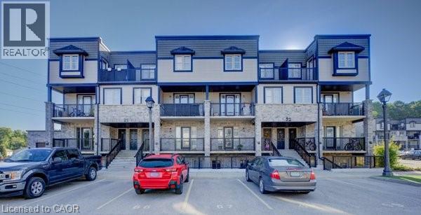 A multi-story apartment building with cars parked in front.