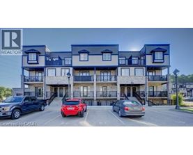 A multi-story apartment building with cars parked in front.