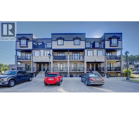 A multi-story apartment building with cars parked in front.
