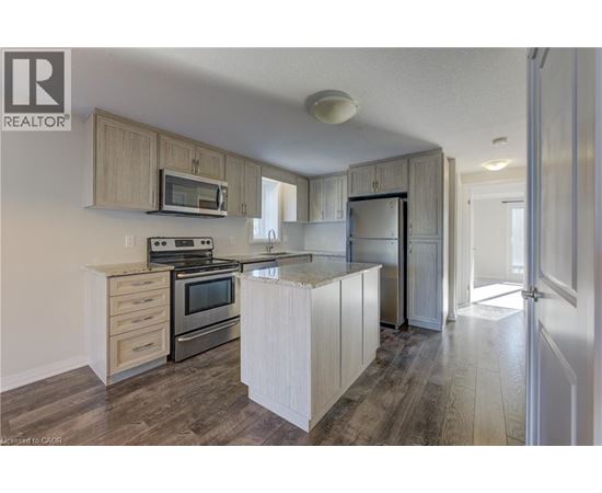 A kitchen with wooden cabinets and a microwave above the stove.