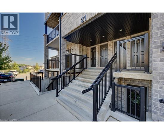 A building with a black railing and steps leading to a door.