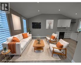 A living room with a white couch, orange pillows, and a wooden coffee table.