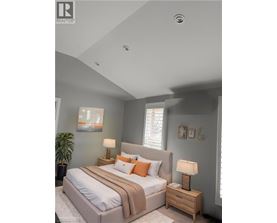 A bedroom with a large bed and a lamp on the nightstand.
