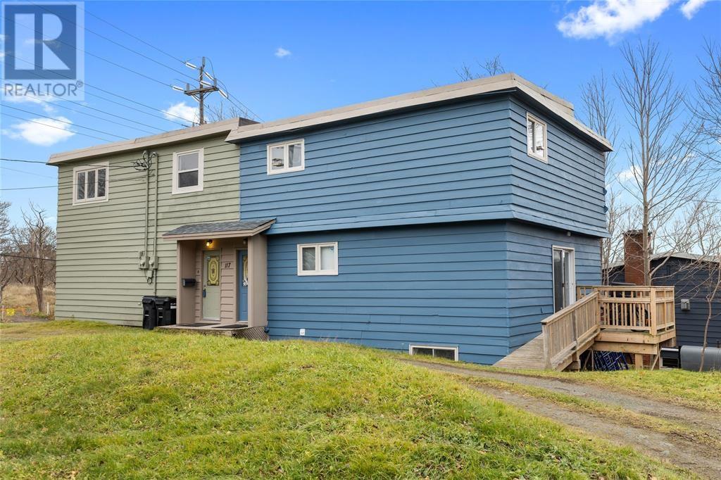 A blue house with a wooden deck in front.