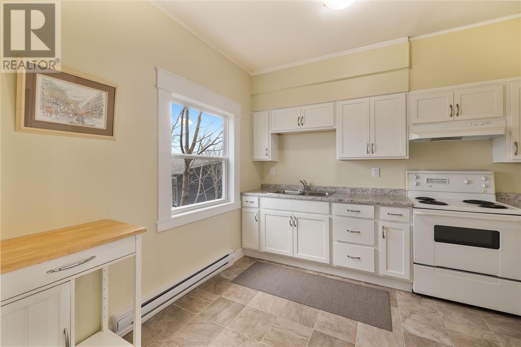 A kitchen with white cabinets and a wooden countertop.