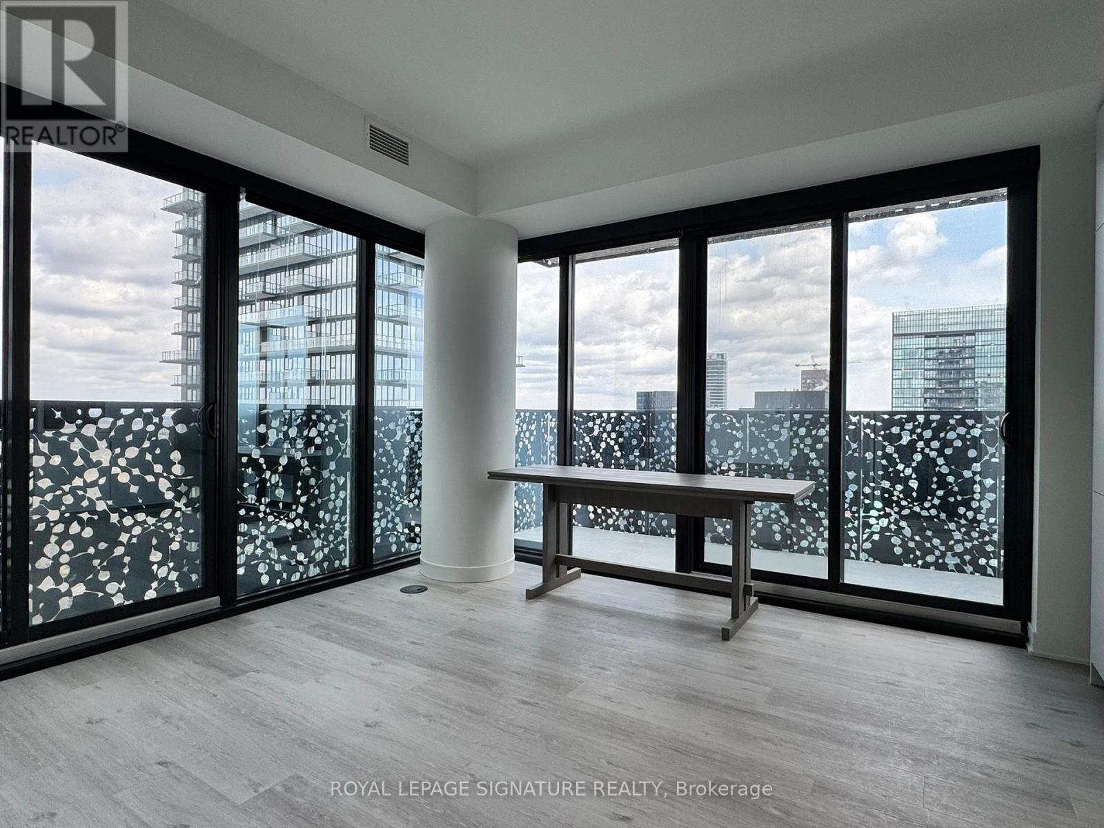 A room with a table and a bench with a view of the city.