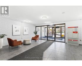 A real estate brokerage office with a white brick wall and a glass door.