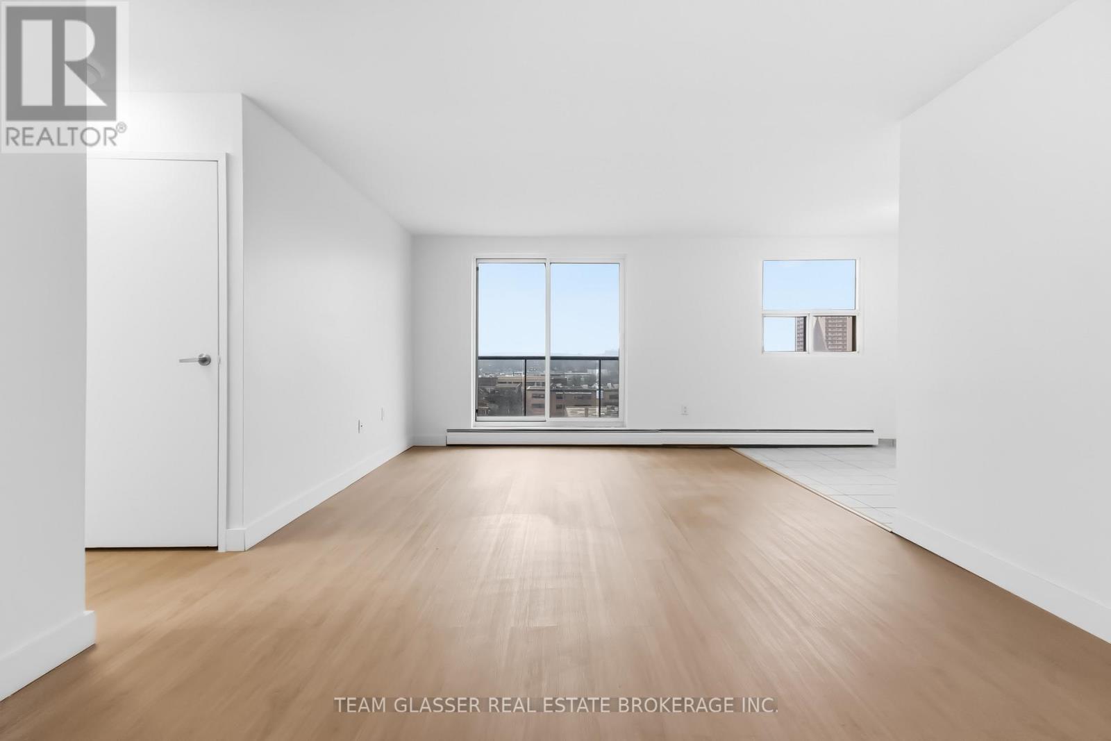 A large empty room with wooden floors and white walls.
