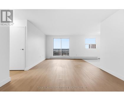 A large empty room with wooden floors and white walls.