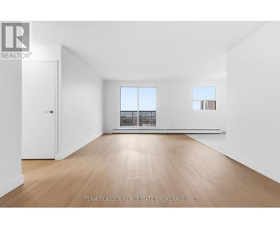 A large empty room with wooden floors and white walls.