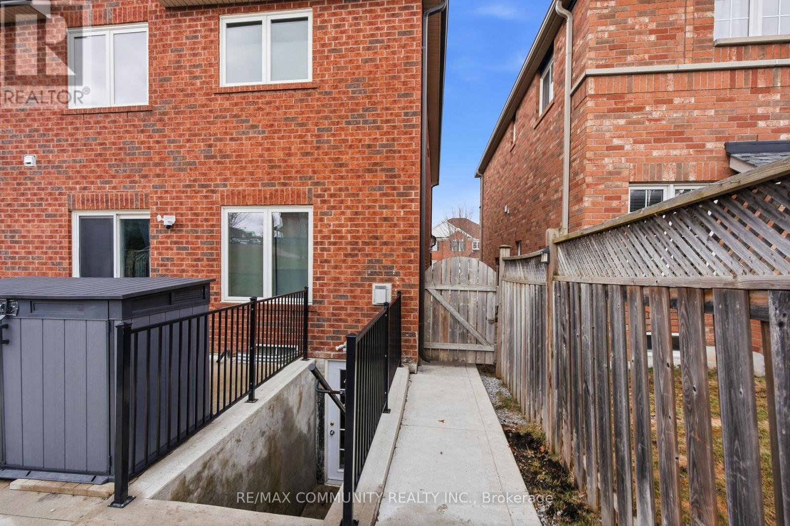 A red brick building with a black fence and gate.