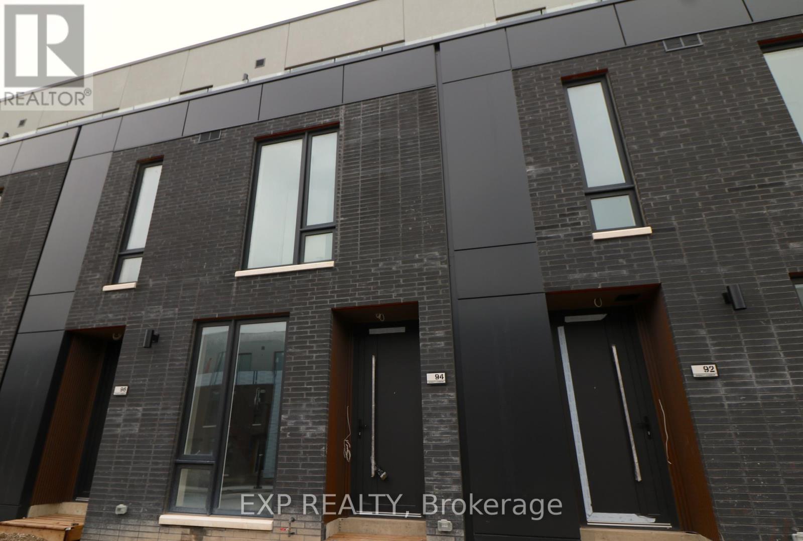 A building with windows and doors is shown with EXP REALTY Brokerage in the foreground.