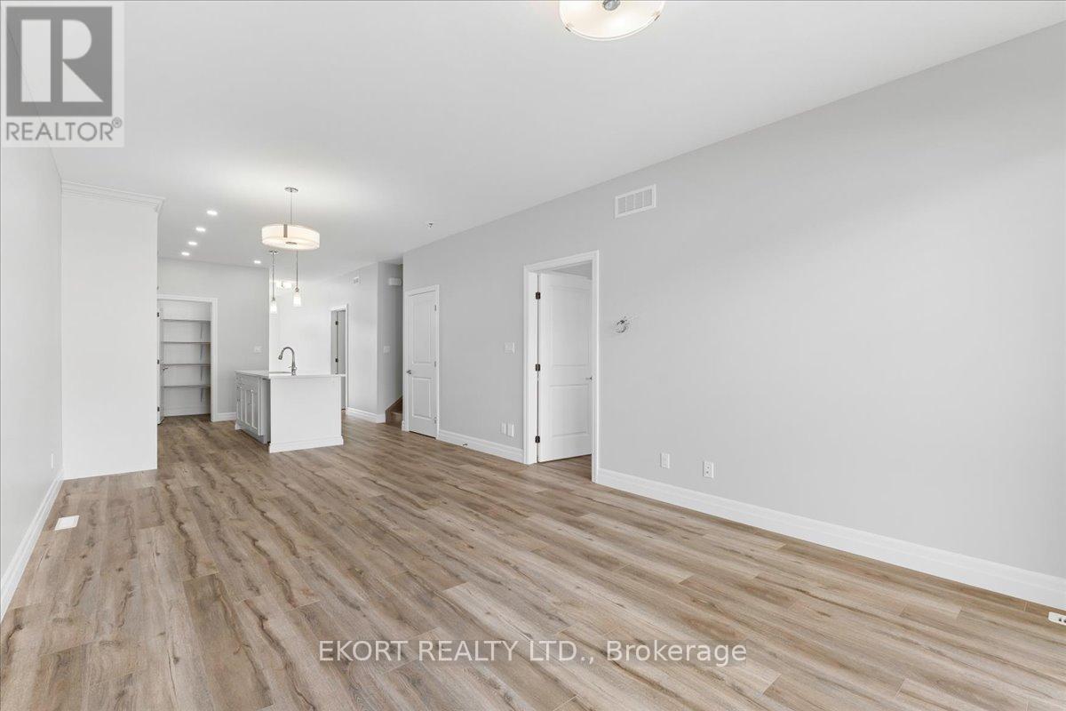 A spacious room with wooden flooring and white walls, ready for furnishing.