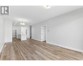 A spacious room with wooden flooring and white walls, ready for furnishing.