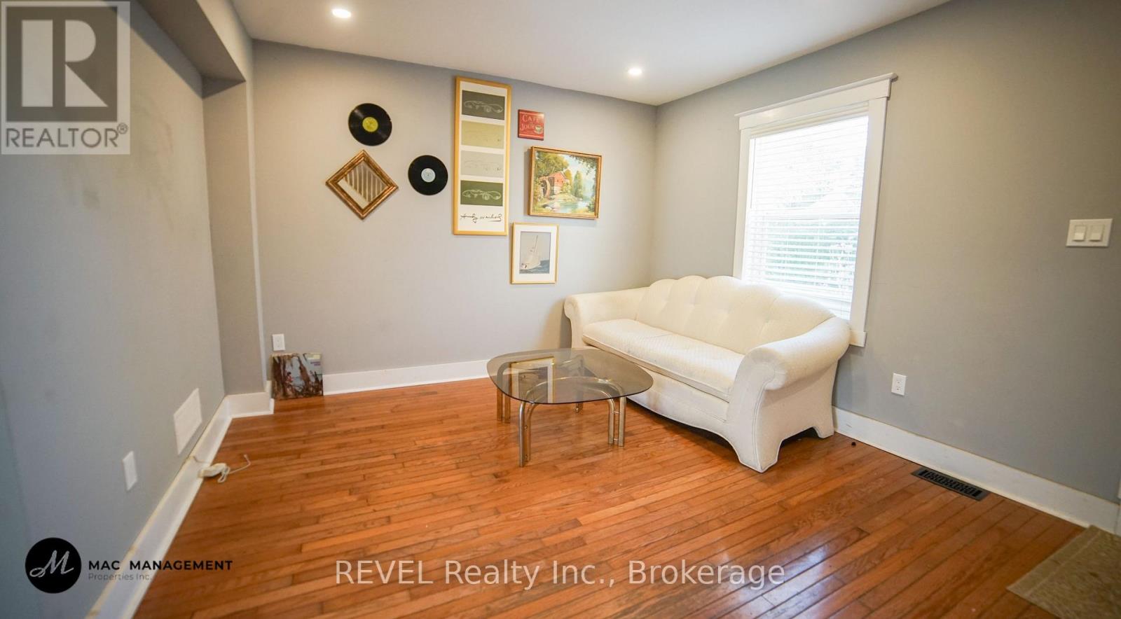 A living room with a white couch and a wooden floor.
