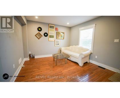 A living room with a white couch and a wooden floor.