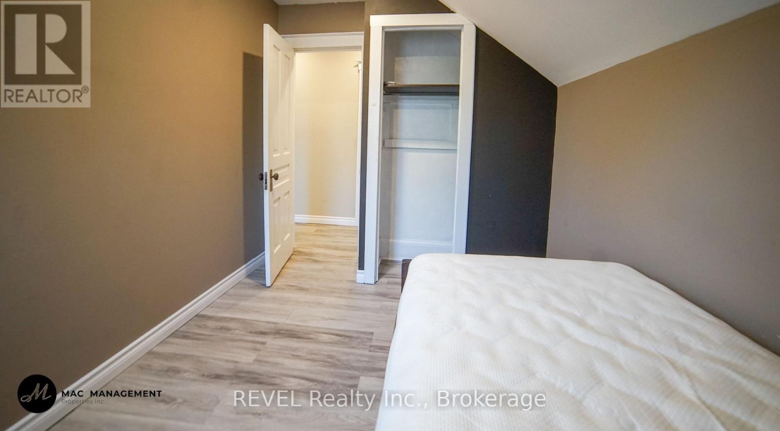 A bedroom with a white bed and a closet with a white door.