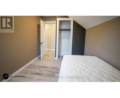 A bedroom with a white bed and a closet with a white door.