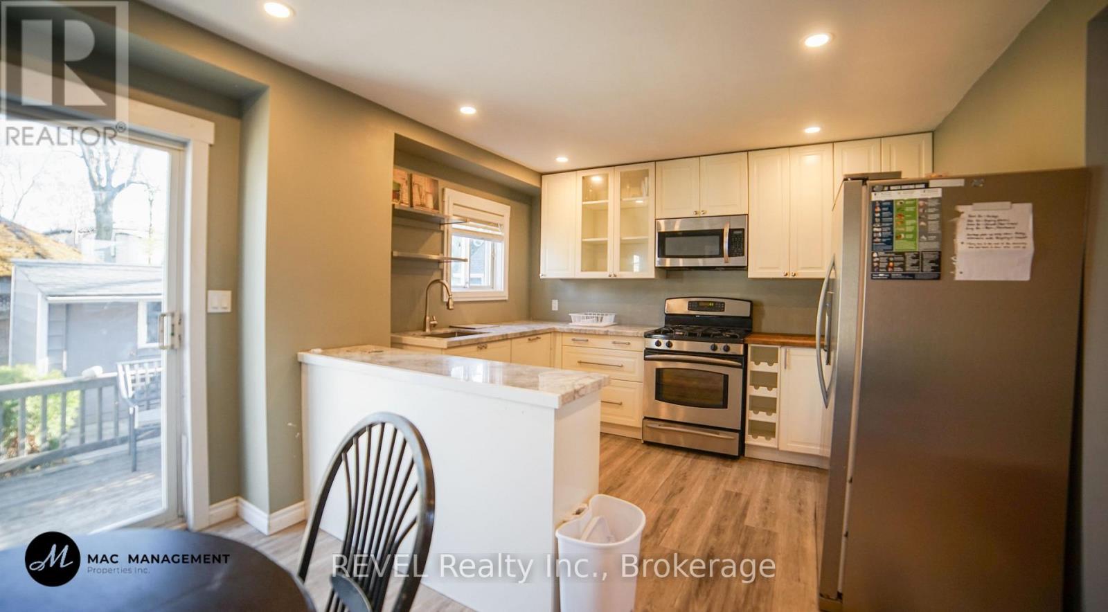 A kitchen with a refrigerator, oven, and microwave.
