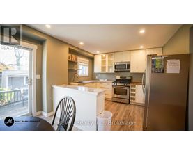 A kitchen with a refrigerator, oven, and microwave.