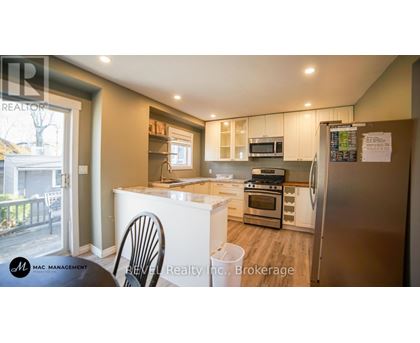 A kitchen with a refrigerator, oven, and microwave.