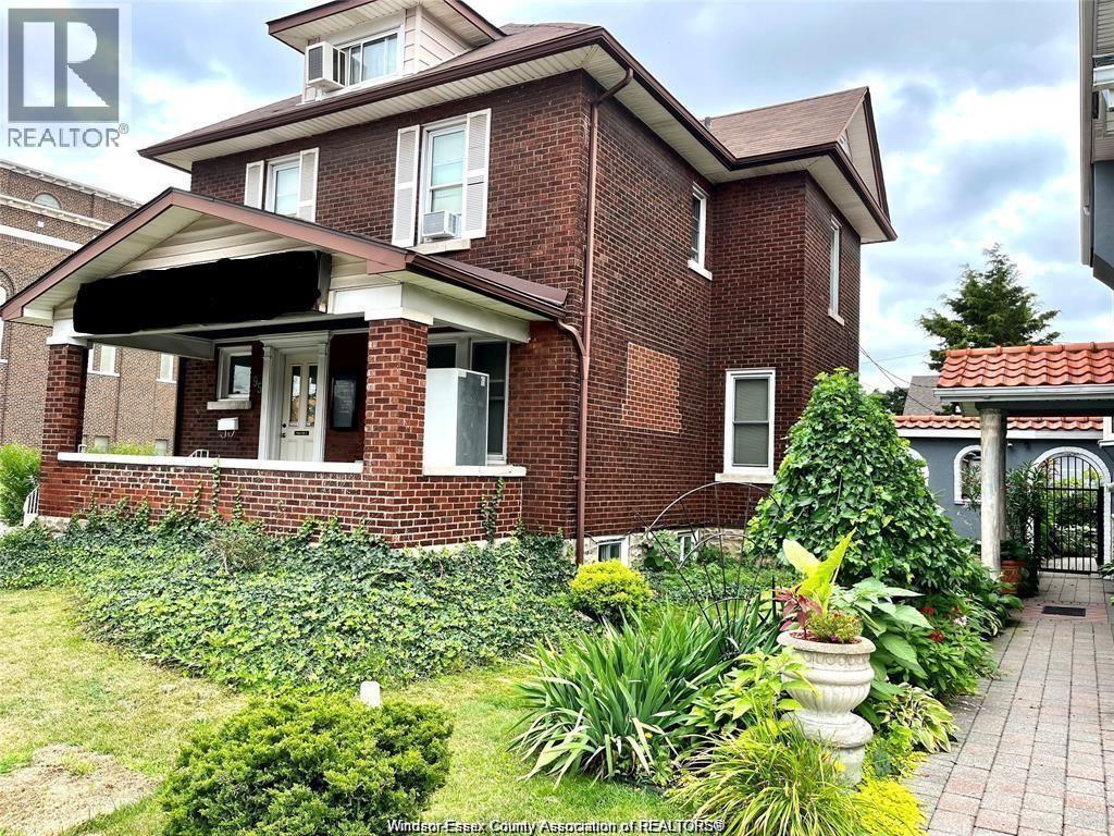 A red brick house with a garden in front.