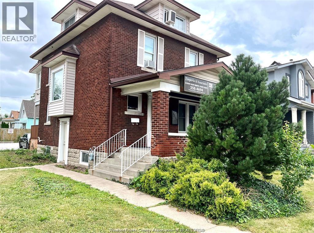 A brick house with a white window and a sign that says REALTOR.