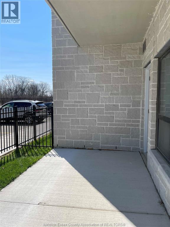 A grey stone wall with a black iron gate in front.