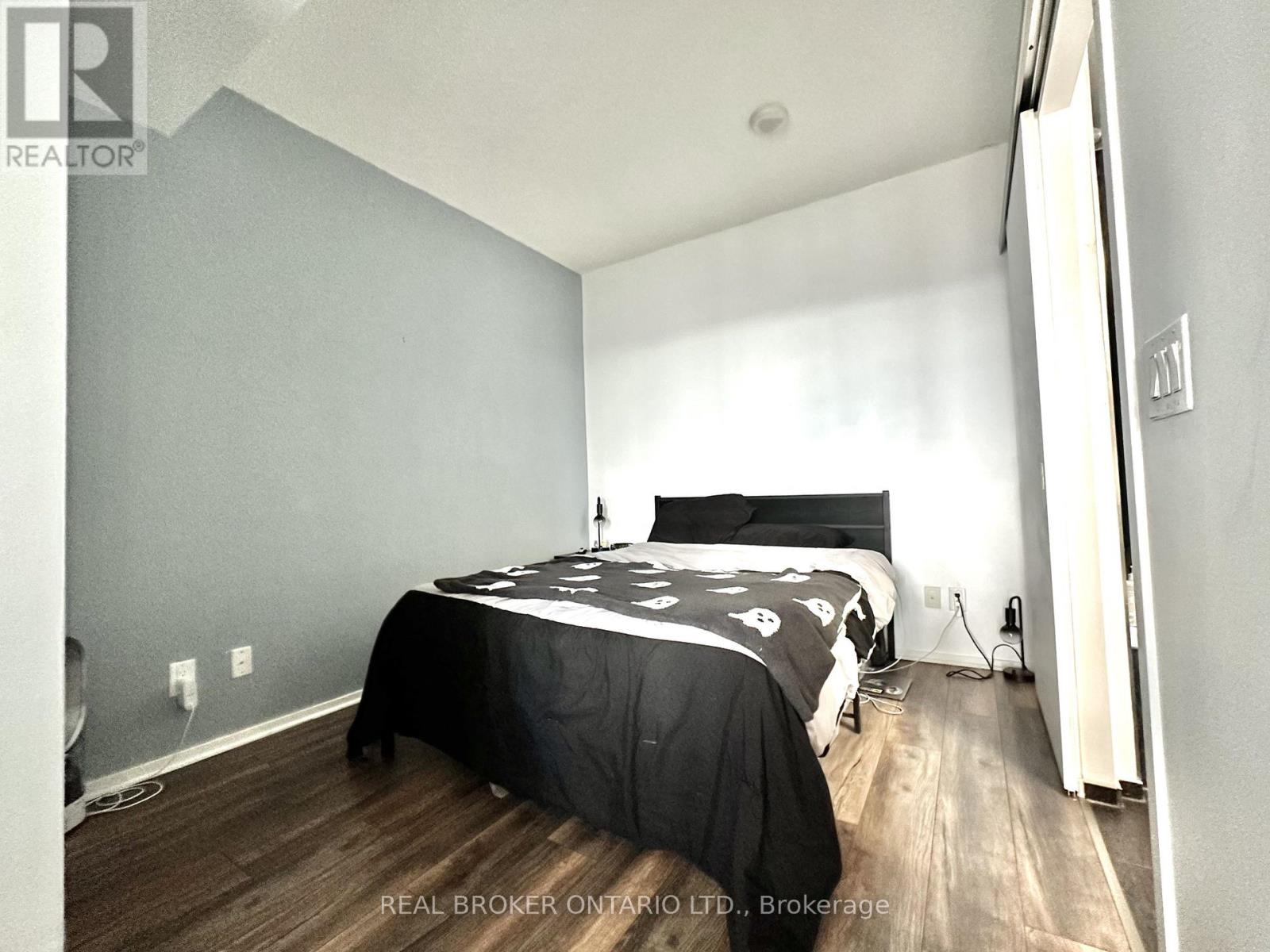 A bedroom with a bed covered in a black and white comforter.
