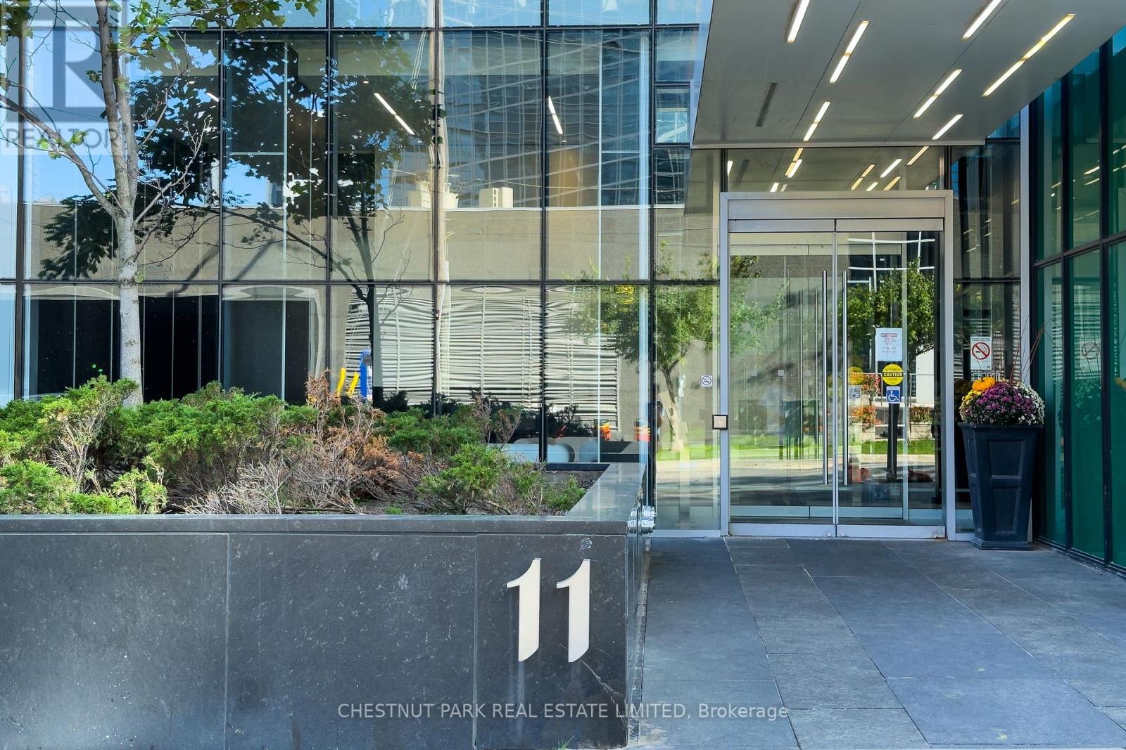 The entrance to a building with a glass door and a sign that reads "11 Chestnut Park Real Estate Limited, Brokerage".