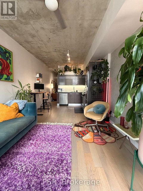 A living room with a blue couch and a purple rug.