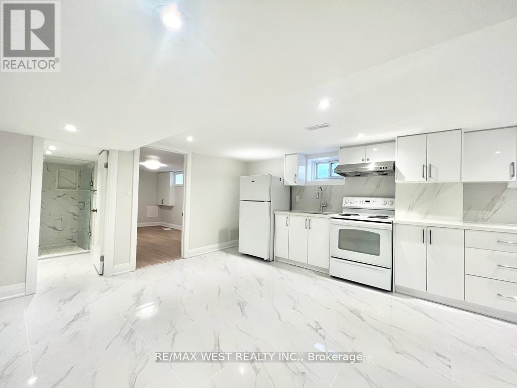 A white kitchen with a marble floor and white cabinets.