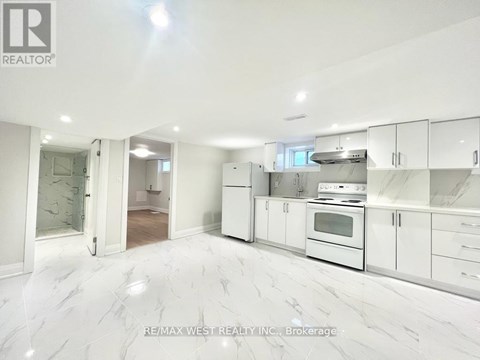 A white kitchen with a marble floor and white cabinets.