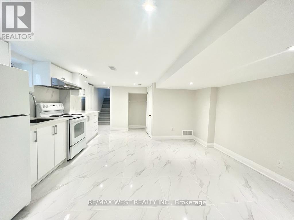 A spacious kitchen with white appliances and marble flooring.