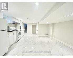 A spacious kitchen with white appliances and marble flooring.