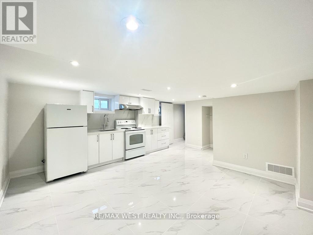 A spacious kitchen with white appliances and cabinets.