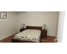 A bedroom with a bed and two nightstands with lamps.