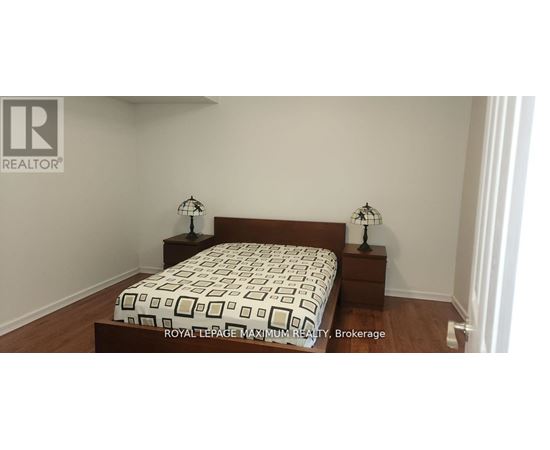 A bedroom with a bed and two nightstands with lamps.