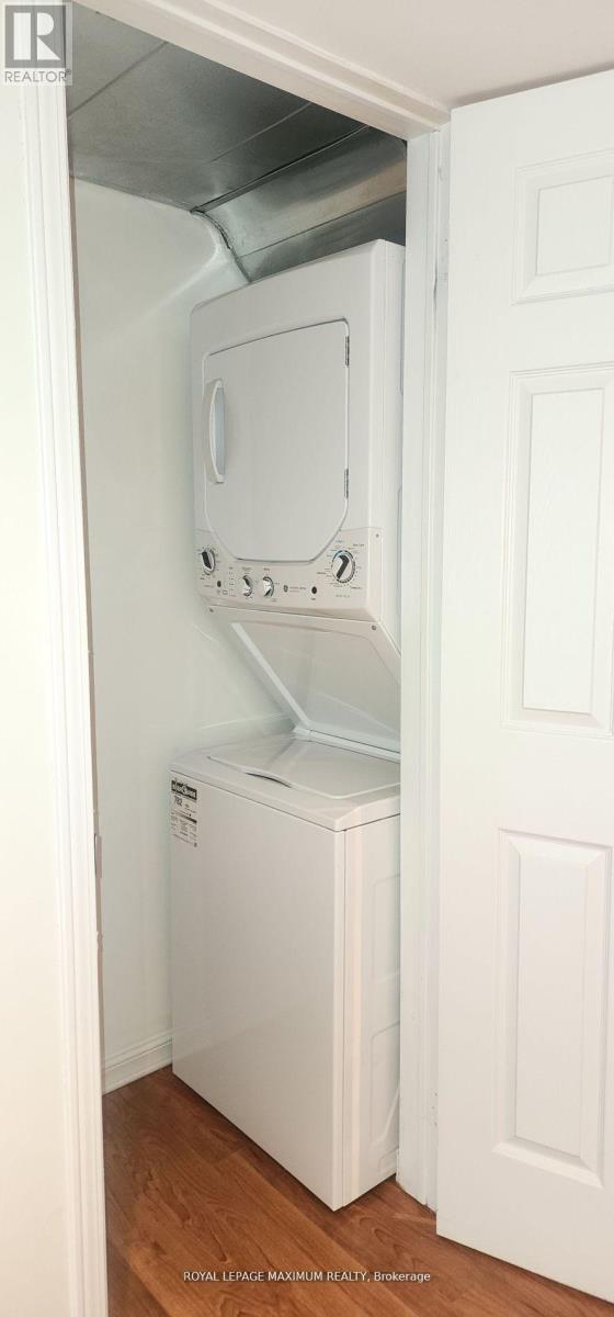 A white refrigerator is installed in a narrow space under a door.