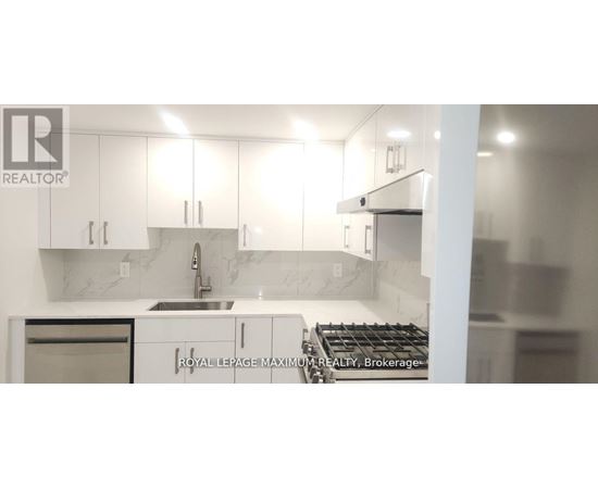 A modern kitchen with white cabinets and a marble backsplash.
